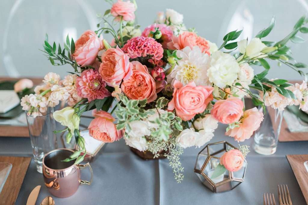 Coral garden rose and dahlia centerpiece on styled table setting