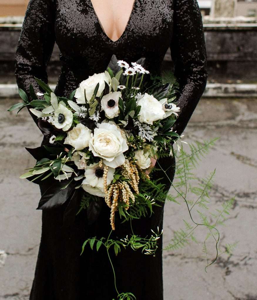 White garden rose and anemone bouquet against black sequin gown