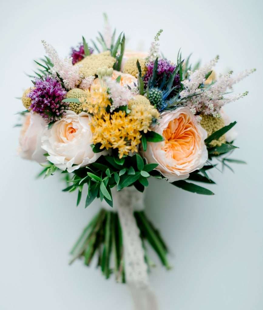 Peach garden rose bouquet with thistle and purple wildflower accents