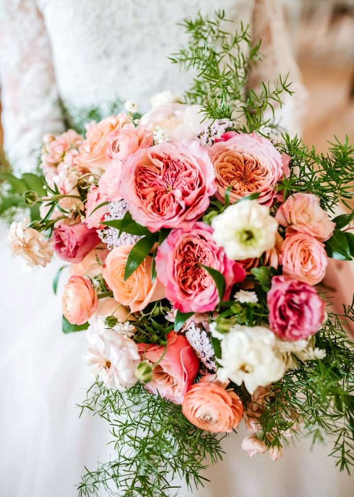 Coral and pink garden rose bouquet with airy greenery