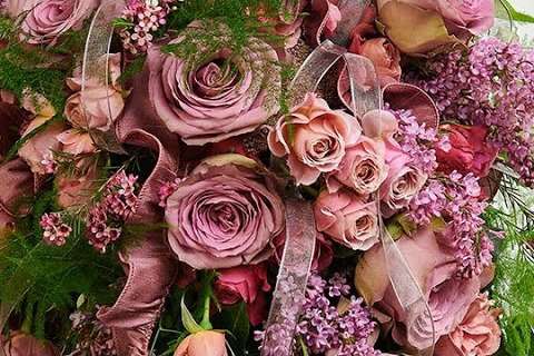 Close-up of mauve garden roses and lilac in a cascading bouquet