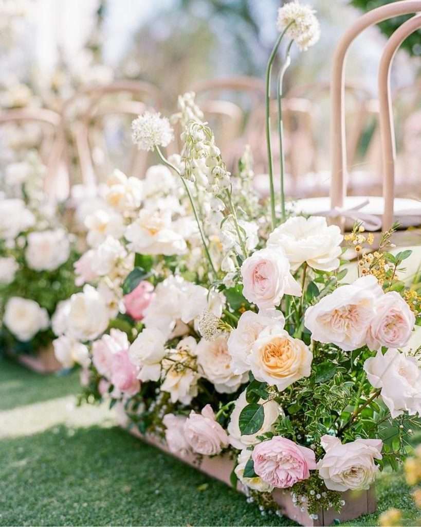 Ceremony aisle lined with blush and ivory garden rose arrangements