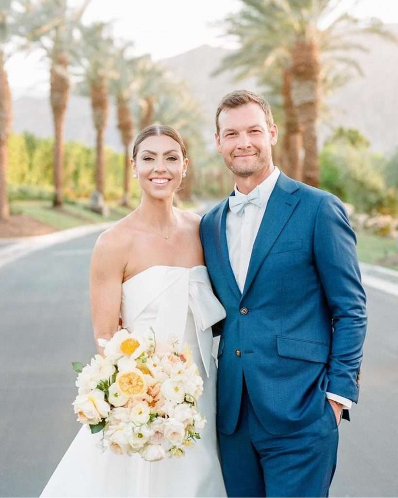 Bride and groom smiling together on a palm-lined road