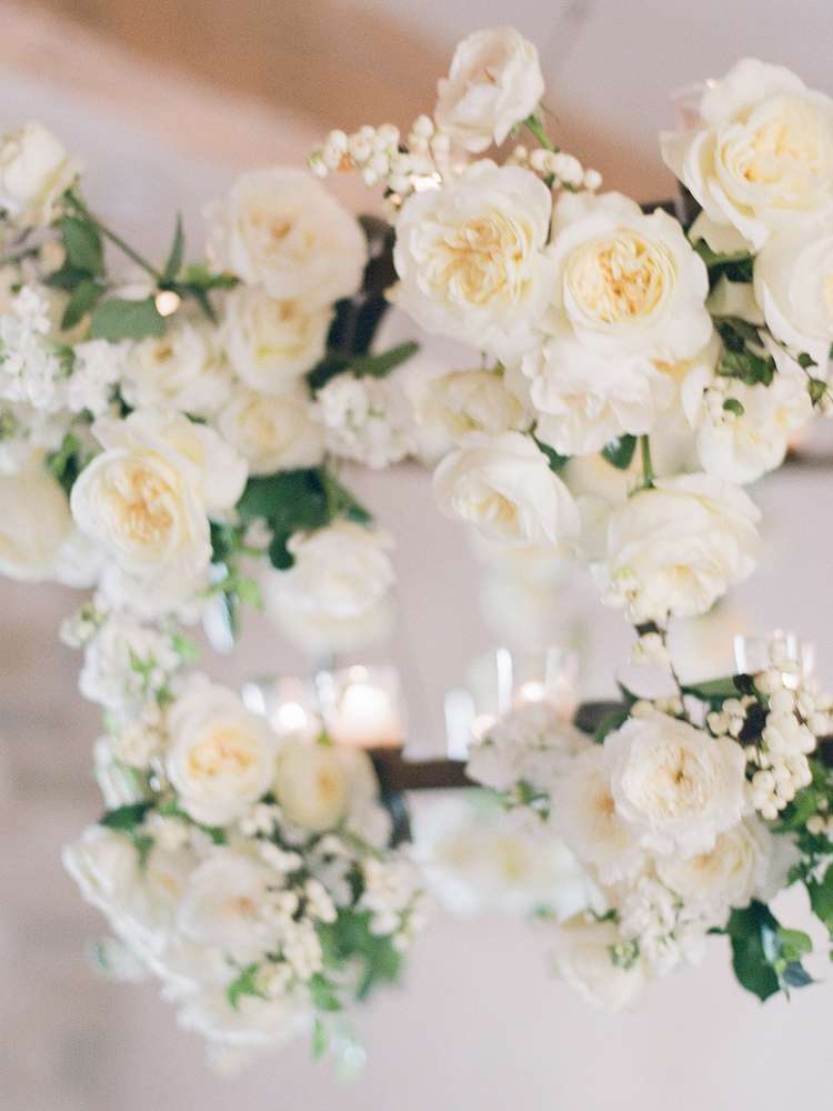 Close-up of ivory garden roses and baby's breath in a hanging chandelier