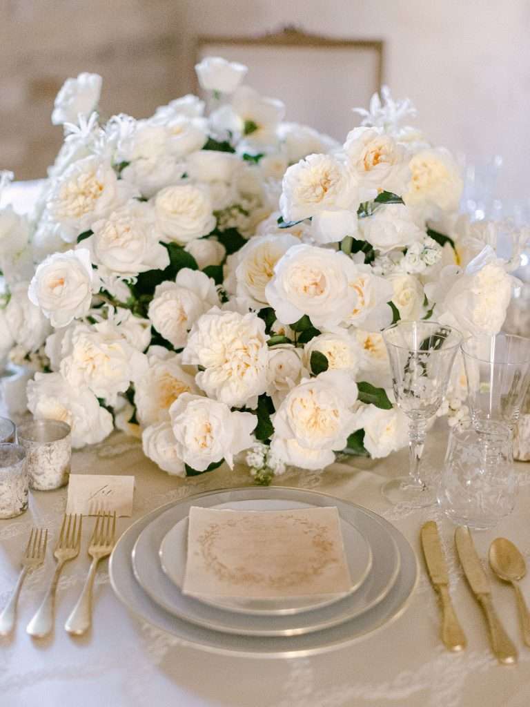 White garden rose centerpiece on a formal winter wedding table setting