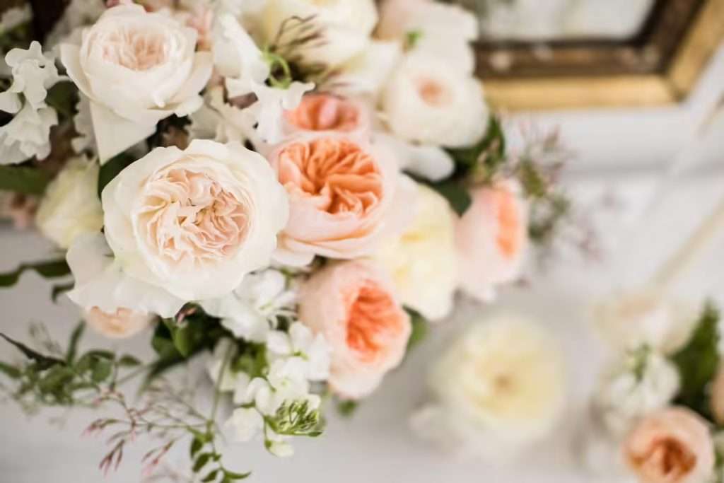Close-up of ivory, blush and apricot garden roses in a table arrangement