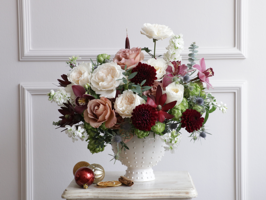 White and burgundy garden roses with dahlias in a hobnail vase for winter wedding