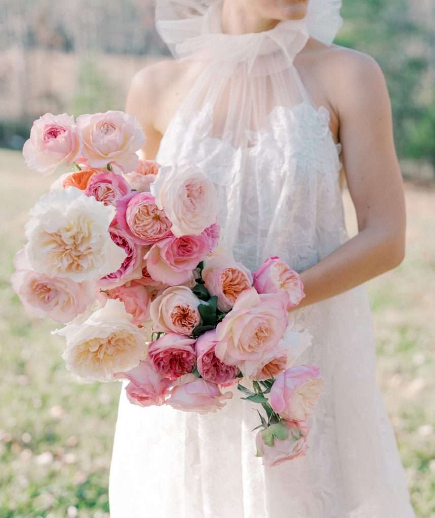 Bride holding a blush, coral and ivory garden rose bouquet
