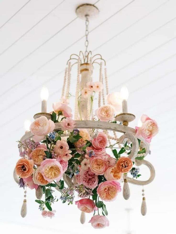 Vintage chandelier wrapped in pink and peach garden roses and trailing greenery