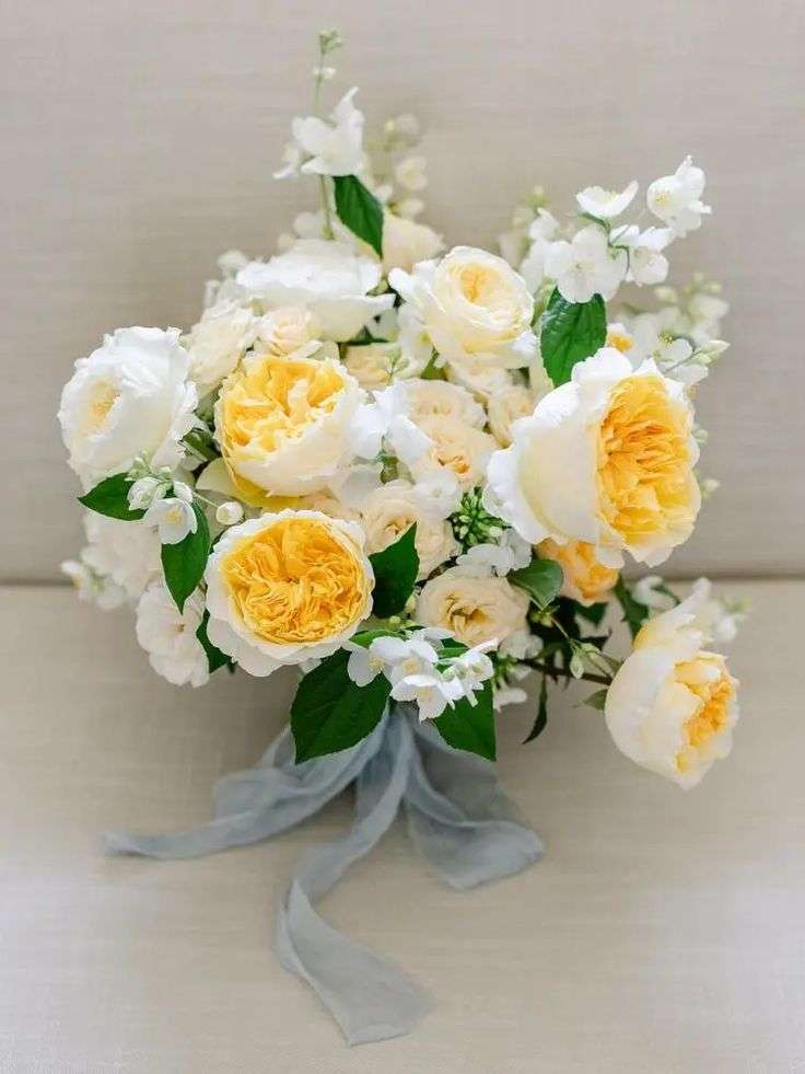 Overhead view of bridal bouquet with apricot Effie garden roses, white blooms and grey ribbon