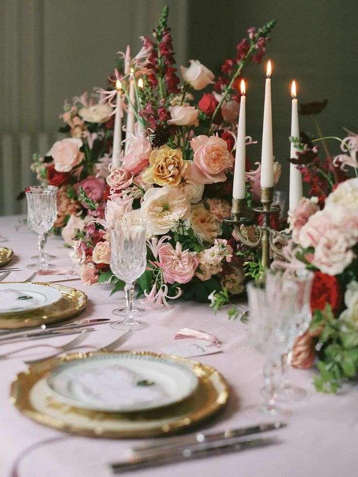 Wedding tablescape with garden roses, snapdragons and taper candles on gold chargers