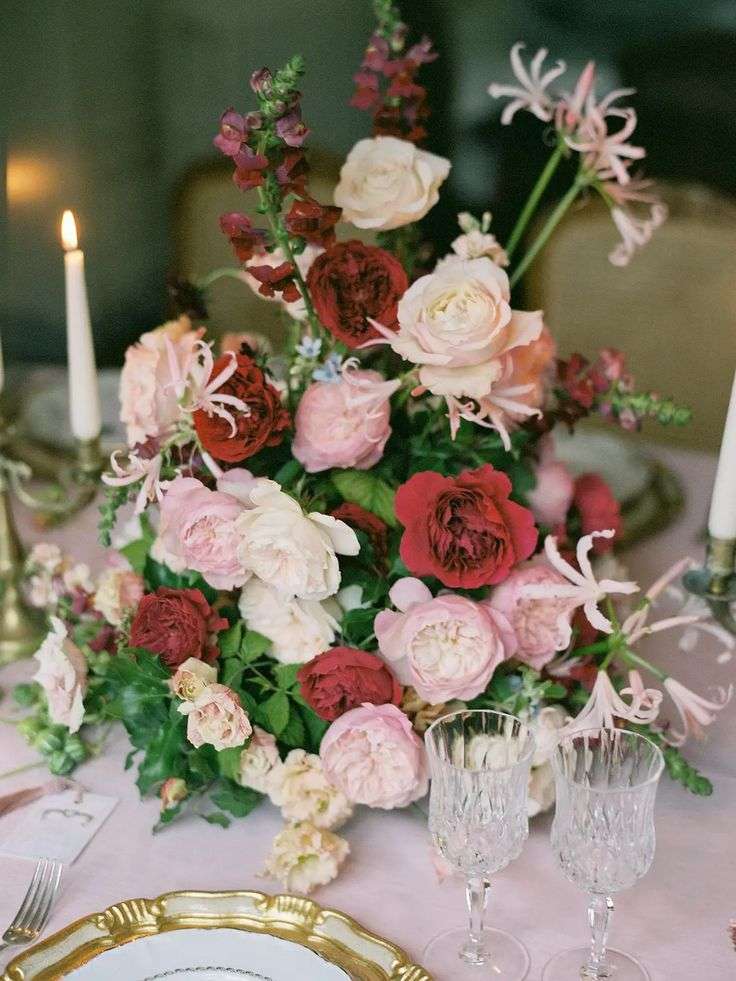 Dutch Masters style centerpiece with deep red and blush garden roses and candlelight