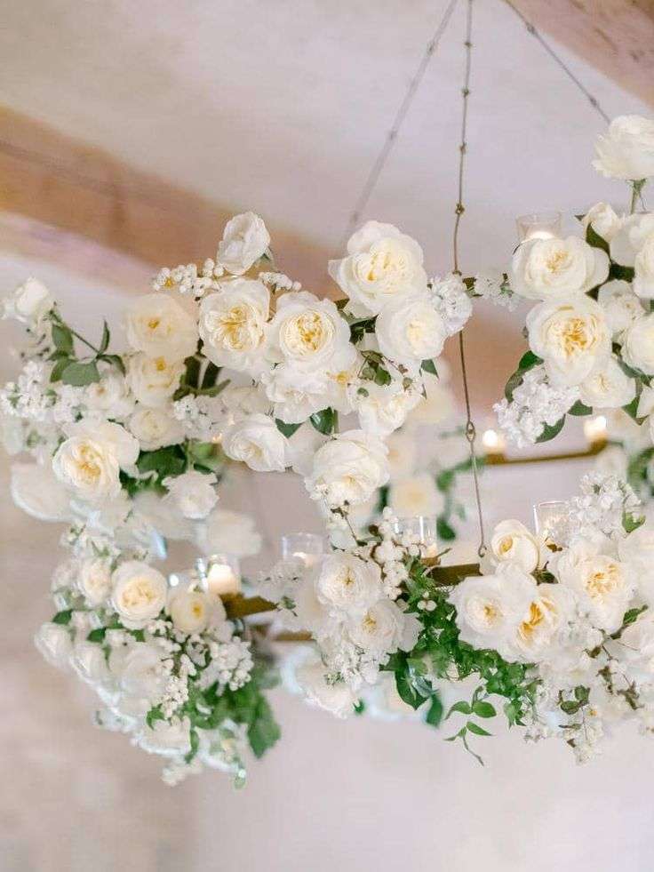 Close-up of a floral hoop chandelier with white garden roses and candles