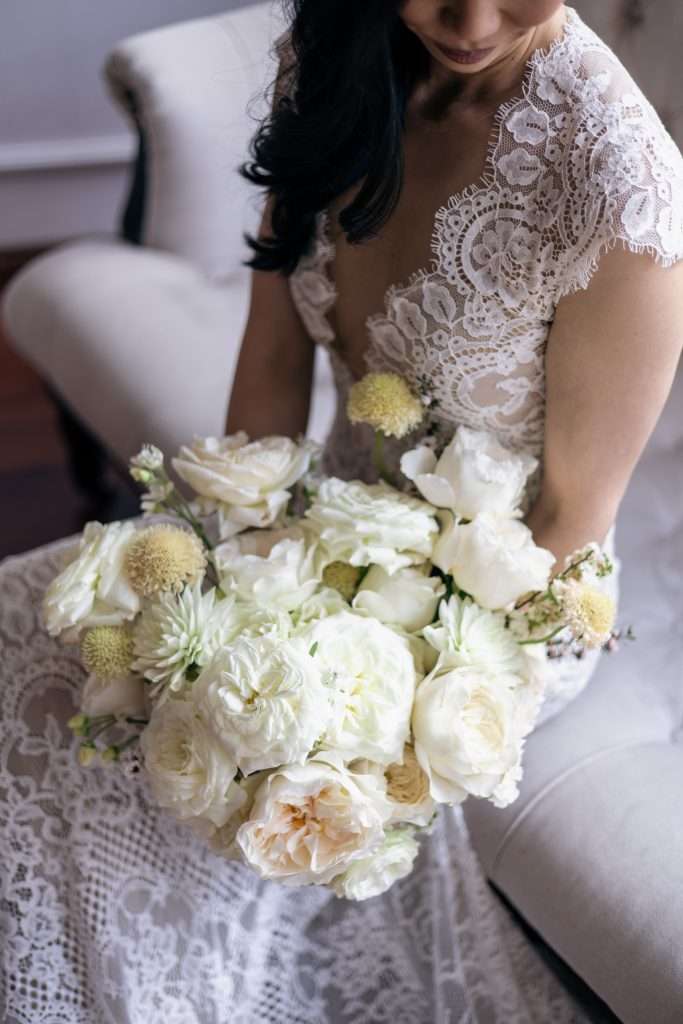 Overhead view of an all-white garden rose and dahlia bouquet