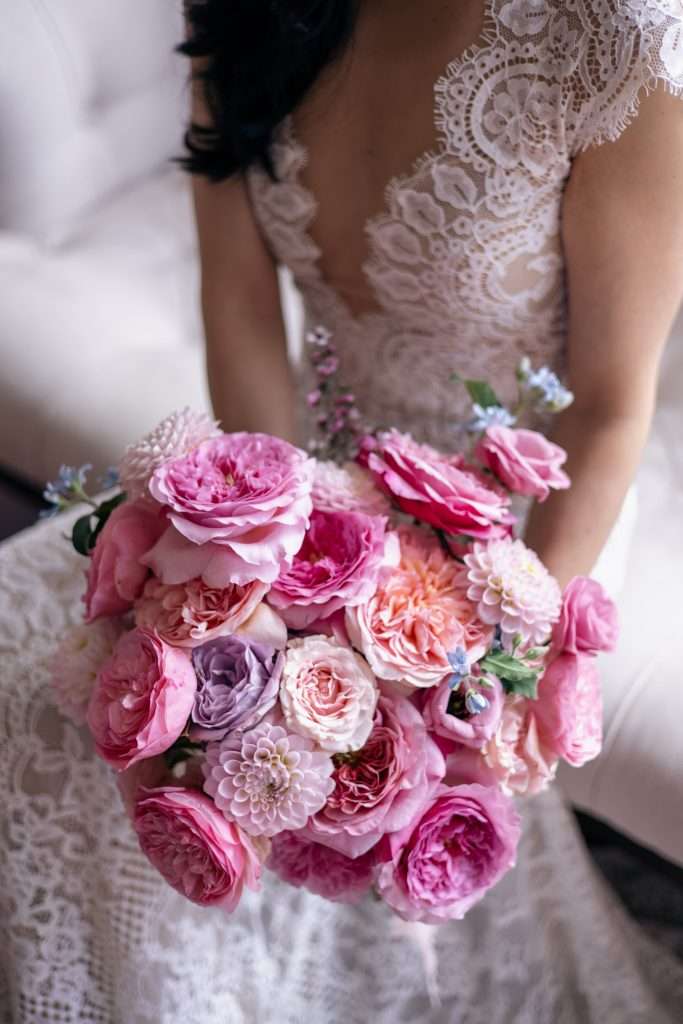 Close-up of a bright pink garden rose bouquet with dahlias and ranunculus