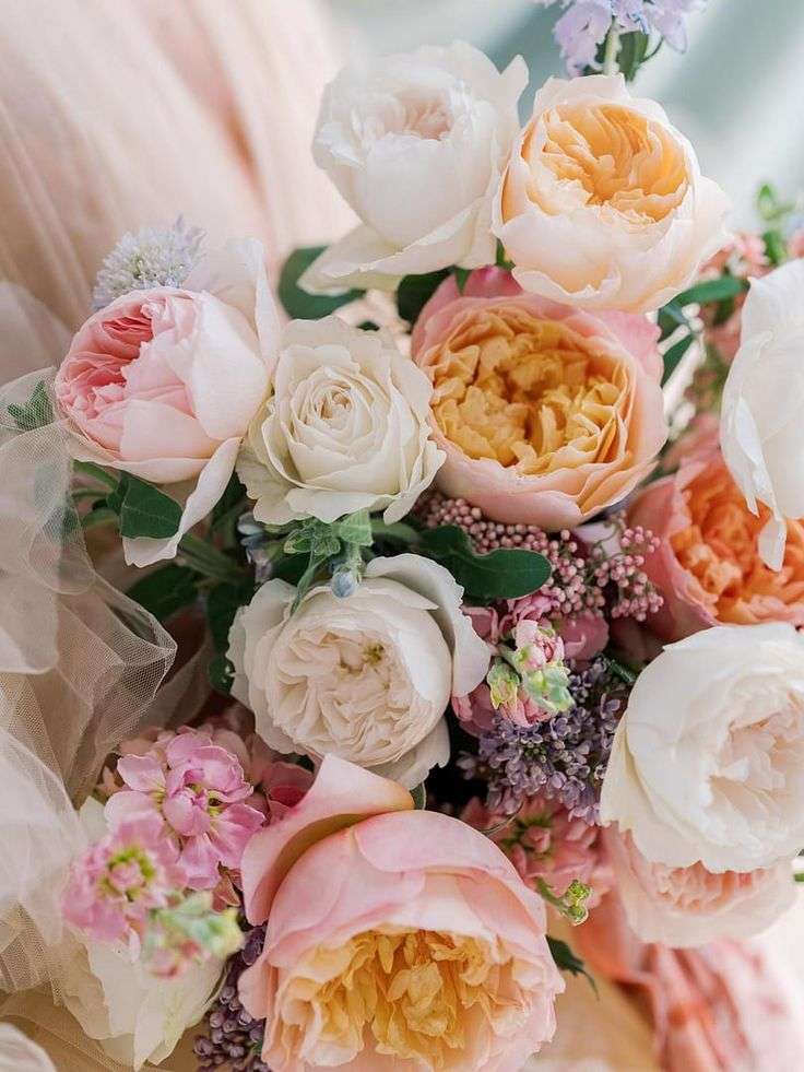Close-up of blush, peach and ivory garden roses with stock and lilac